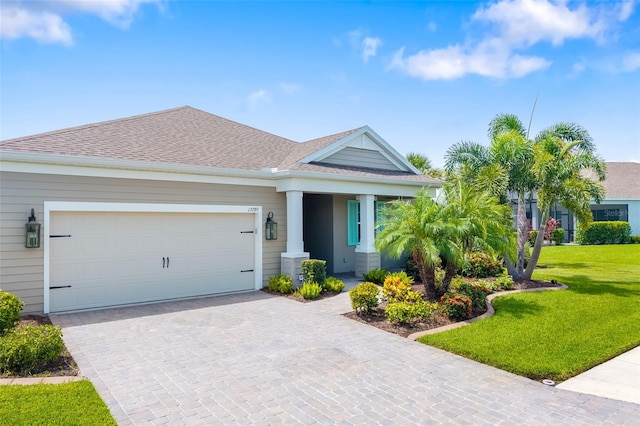 13789 Old Creek Ct, Parrish, FL 34219 - view of front of property with decorative driveway, a front yard, a garage, and a shingled roof