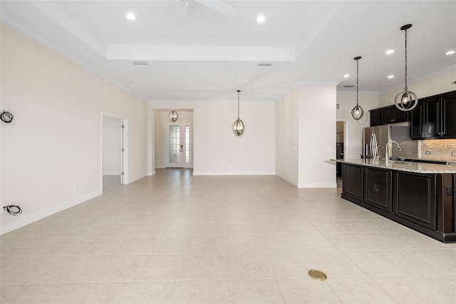 13789 Old Creek Ct, Parrish, FL 34219 - kitchen with a tray ceiling, light tile patterned floors, dark cabinets, backsplash, and freestanding refrigerator