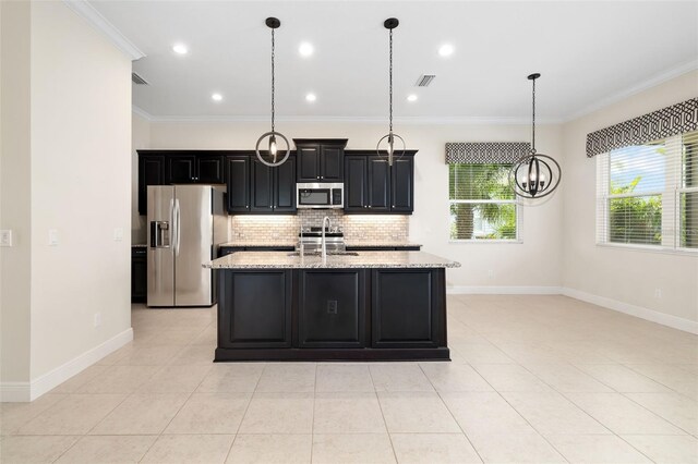 13789 Old Creek Ct, Parrish, FL 34219 - kitchen with appliances with stainless steel finishes, dark cabinetry, tasteful backsplash, a kitchen island with sink, and crown molding