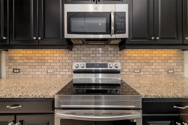 13789 Old Creek Ct, Parrish, FL 34219 - kitchen with stainless steel appliances, backsplash, dark cabinets, and light stone countertops
