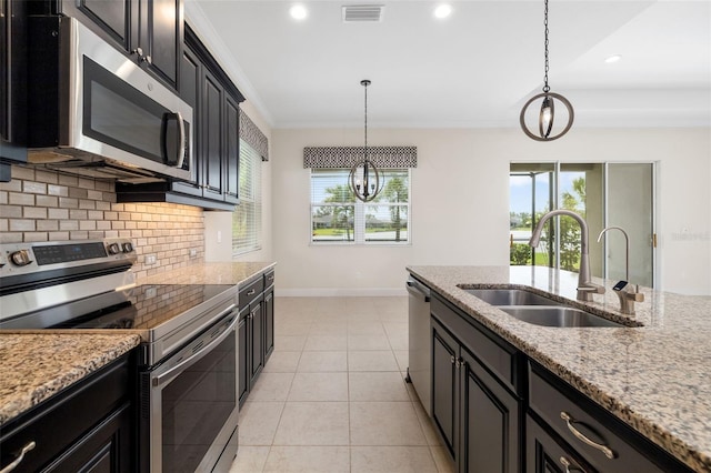 13789 Old Creek Ct, Parrish, FL 34219 - kitchen with stainless steel appliances, dark cabinetry, tasteful backsplash, decorative light fixtures, and recessed lighting