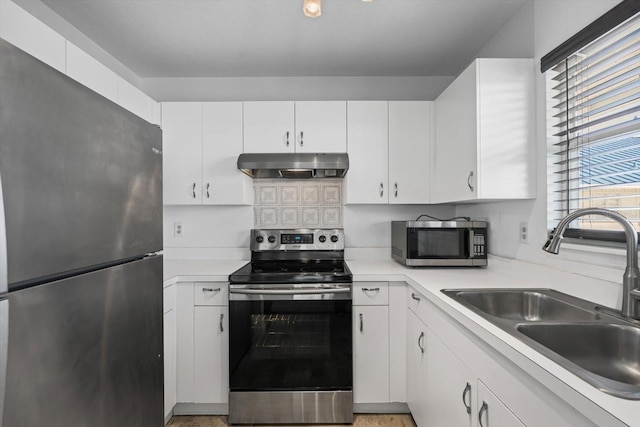 970 Sandpiper Cir Unit 970, Bradenton, FL 34209 - kitchen with appliances with stainless steel finishes, light countertops, under cabinet range hood, and white cabinetry