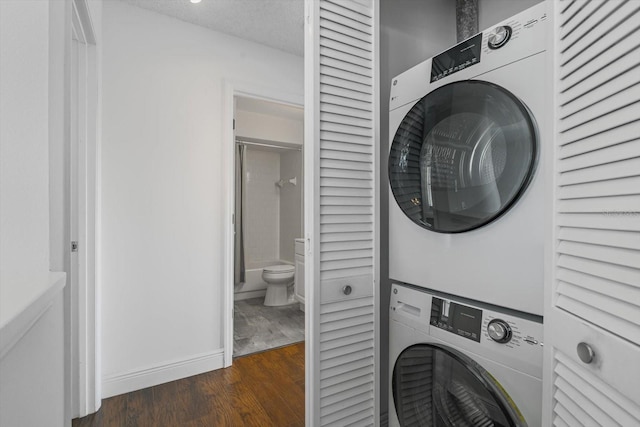 970 Sandpiper Cir Unit 970, Bradenton, FL 34209 - washroom featuring stacked washing machine and dryer and wood finished floors