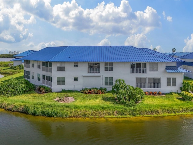 970 Sandpiper Cir Unit 970, Bradenton, FL 34209 - back of house with a water view, a lawn, and a metal roof