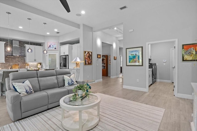 3605 Wild Blossom Pl, Parrish, FL 34219 - living room featuring ceiling fan, light wood-type flooring, a towering ceiling, washing machine and clothes dryer, and recessed lighting