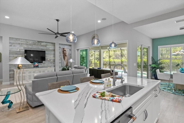 3605 Wild Blossom Pl, Parrish, FL 34219 - kitchen featuring white cabinets, recessed lighting, ceiling fan, open floor plan, and light stone counters