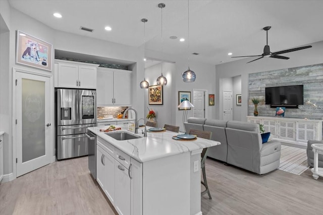 3605 Wild Blossom Pl, Parrish, FL 34219 - kitchen with appliances with stainless steel finishes, open floor plan, recessed lighting, light wood-type flooring, and white cabinets