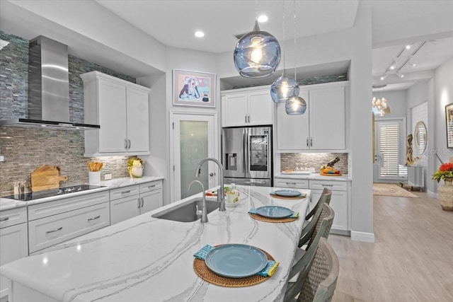 3605 Wild Blossom Pl, Parrish, FL 34219 - kitchen with stainless steel fridge, wall chimney exhaust hood, white cabinetry, tasteful backsplash, and recessed lighting