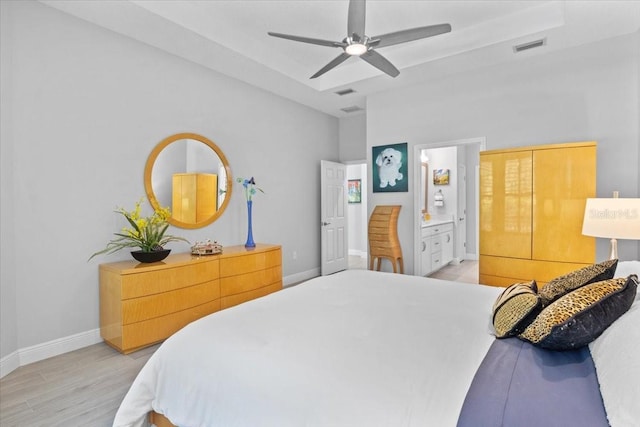 3605 Wild Blossom Pl, Parrish, FL 34219 - bedroom featuring light wood-style flooring, connected bathroom, and ceiling fan