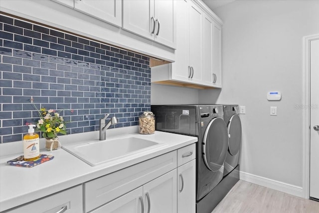3605 Wild Blossom Pl, Parrish, FL 34219 - laundry room with washer and dryer, cabinet space, and light wood-style flooring