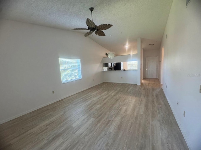 7301 29th Avenue Dr W Unit 310, Bradenton, FL 34209 - unfurnished living room with lofted ceiling, a textured ceiling, wood finished floors, and ceiling fan