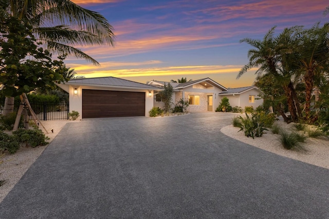 615 Concord Ln, Holmes Beach, FL 34217 - view of front of home with driveway, an attached garage, a metal roof, and stucco siding
