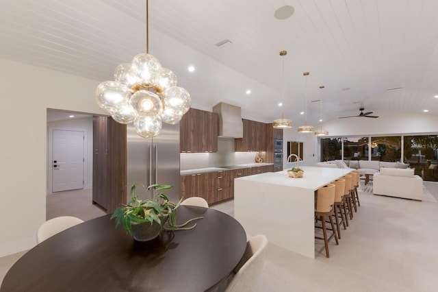 615 Concord Ln, Holmes Beach, FL 34217 - kitchen with modern cabinets, built in fridge, vaulted ceiling, a spacious island, and wall chimney exhaust hood