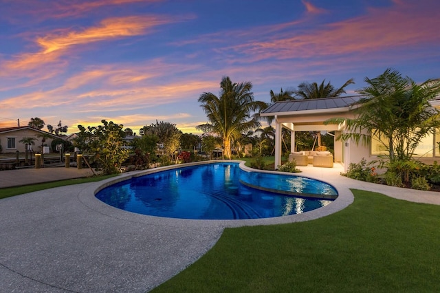 615 Concord Ln, Holmes Beach, FL 34217 - pool at dusk featuring an outdoor hangout area, an outdoor pool, a yard, and a patio