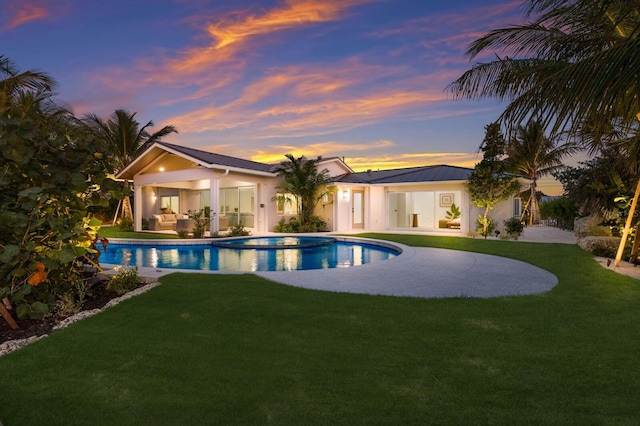 615 Concord Ln, Holmes Beach, FL 34217 - pool at dusk featuring an outdoor pool, a lawn, a patio, and outdoor lounge area