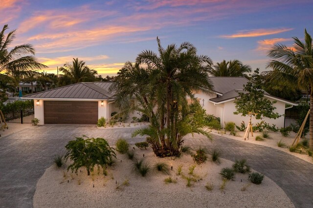 615 Concord Ln, Holmes Beach, FL 34217 - view of front of property with decorative driveway, a garage, a metal roof, a standing seam roof, and stucco siding