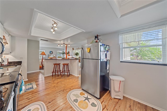 7216 11th Ave W Unit 203, Bradenton, FL 34209 - kitchen featuring stainless steel appliances, track lighting, light wood-style floors, and a breakfast bar area