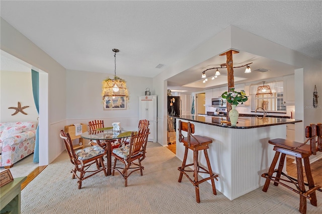 7216 11th Ave W Unit 203, Bradenton, FL 34209 - dining space featuring light colored carpet and a chandelier