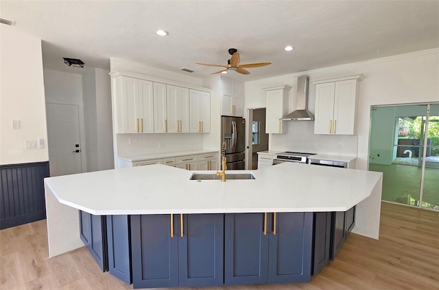 4074 Redbird Cir, Sarasota, FL 34231 - kitchen featuring wall chimney range hood, appliances with stainless steel finishes, ceiling fan, a large island, and light countertops