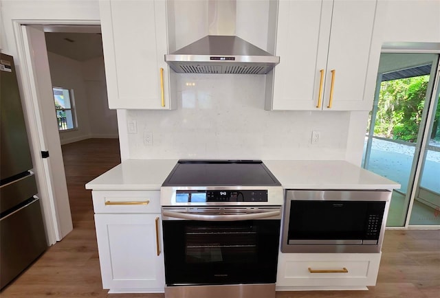 4074 Redbird Cir, Sarasota, FL 34231 - kitchen with wall chimney exhaust hood, stainless steel appliances, light countertops, and plenty of natural light
