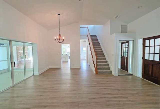 4074 Redbird Cir, Sarasota, FL 34231 - entrance foyer featuring high vaulted ceiling, stairs, light wood-type flooring, and a chandelier