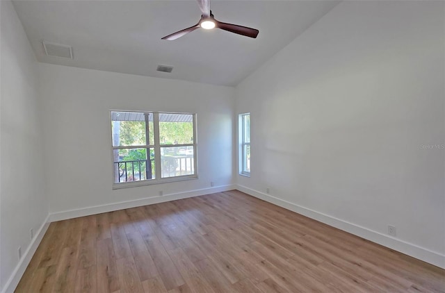 4074 Redbird Cir, Sarasota, FL 34231 - empty room with light wood-style flooring, ceiling fan, and vaulted ceiling