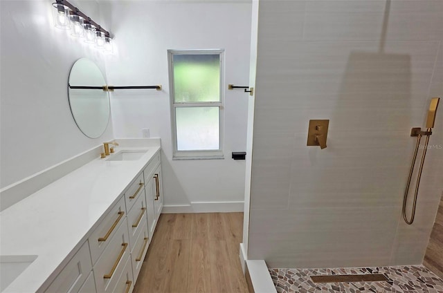 4074 Redbird Cir, Sarasota, FL 34231 - bathroom with double vanity, a tile shower, and wood finished floors