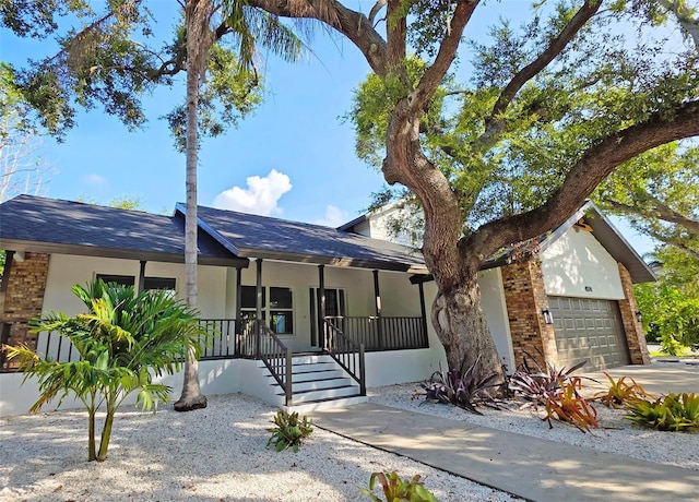 4074 Redbird Cir, Sarasota, FL 34231 - single story home featuring a porch, a garage, roof with shingles, and stucco siding