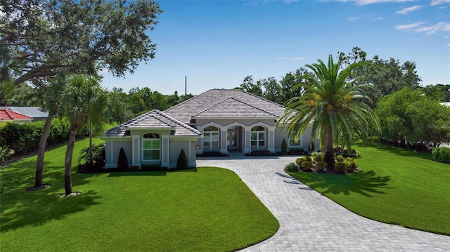462 E Macewen Dr, Osprey, FL 34229 - mediterranean / spanish-style home featuring decorative driveway, a front lawn, stucco siding, and a tile roof
