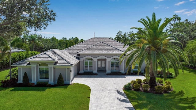 462 E Macewen Dr, Osprey, FL 34229 - mediterranean / spanish home with an attached garage, decorative driveway, a front yard, french doors, and a tiled roof