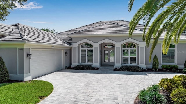 462 E Macewen Dr, Osprey, FL 34229 - view of front of home with french doors, an attached garage, a tiled roof, and decorative driveway