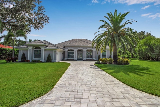 462 E Macewen Dr, Osprey, FL 34229 - mediterranean / spanish house featuring a garage, decorative driveway, a front lawn, stucco siding, and french doors