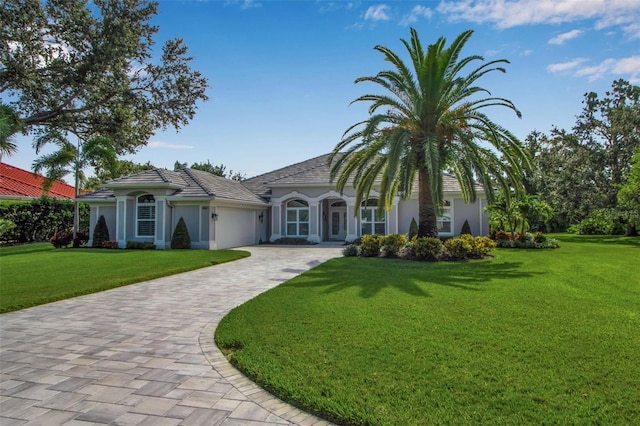462 E Macewen Dr, Osprey, FL 34229 - view of front facade with an attached garage, stucco siding, a front lawn, and decorative driveway
