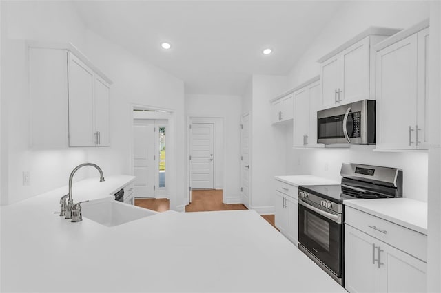 27471 Deep Creek Blvd, Punta Gorda, FL 33983 - kitchen featuring stainless steel appliances, light countertops, white cabinets, recessed lighting, and light wood-style floors