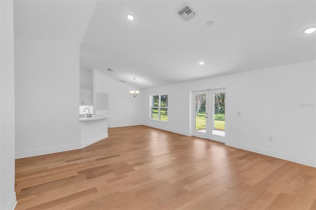 27471 Deep Creek Blvd, Punta Gorda, FL 33983 - unfurnished living room featuring a chandelier, lofted ceiling, light wood finished floors, and recessed lighting