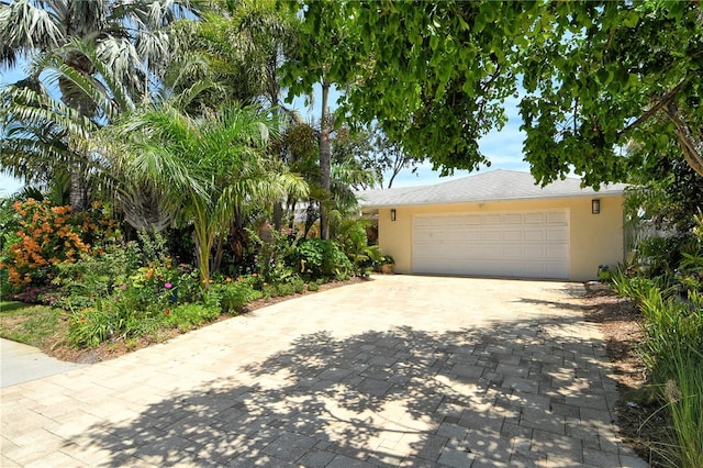 6308 4th Ave NW, Bradenton, FL 34209 - view of property hidden behind natural elements with decorative driveway, stucco siding, and a garage