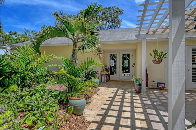 6308 4th Ave NW, Bradenton, FL 34209 - entrance to property featuring french doors, stucco siding, a pergola, and a shingled roof
