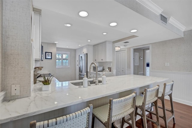 6480 Midnight Pass Rd Unit 211, Sarasota, FL 34242 - kitchen with dark wood-style floors, a peninsula, light stone counters, stainless steel refrigerator with ice dispenser, and a kitchen bar