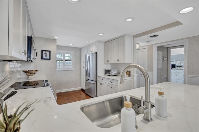 6480 Midnight Pass Rd Unit 211, Sarasota, FL 34242 - kitchen with white cabinetry, stainless steel appliances, dark wood-type flooring, light stone counters, and backsplash