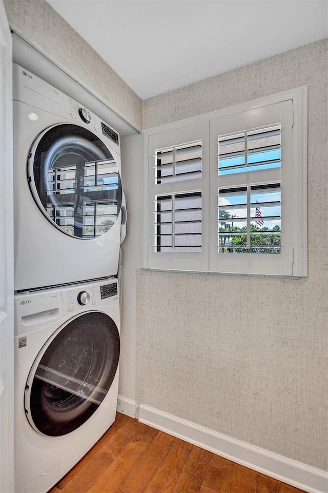6480 Midnight Pass Rd Unit 211, Sarasota, FL 34242 - washroom with stacked washer / dryer and wood finished floors