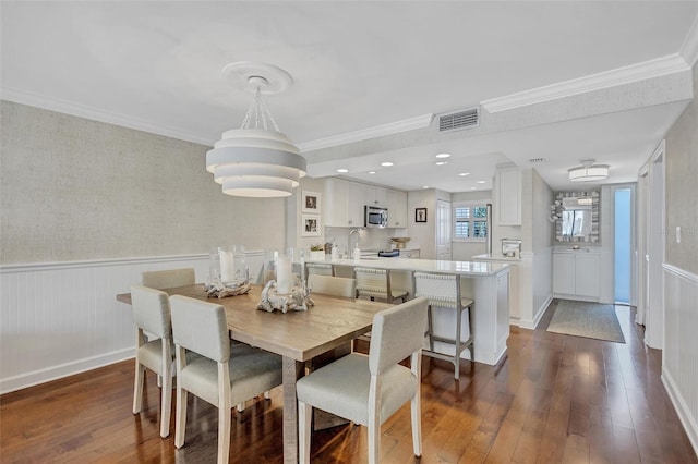 6480 Midnight Pass Rd Unit 211, Sarasota, FL 34242 - dining space featuring dark wood finished floors, a wainscoted wall, crown molding, and wallpapered walls