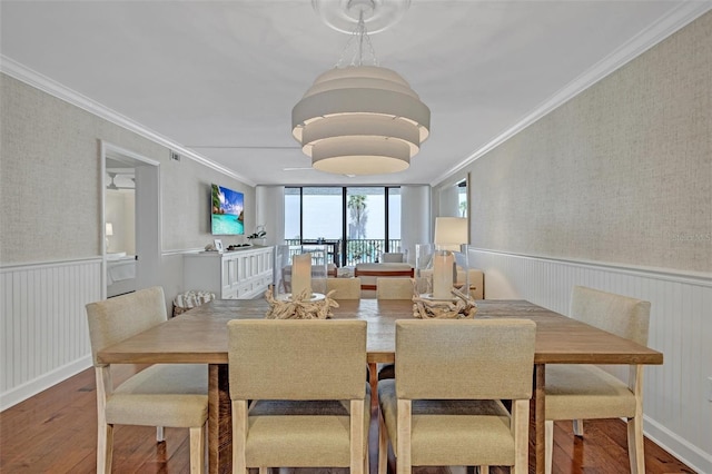 6480 Midnight Pass Rd Unit 211, Sarasota, FL 34242 - dining space with wood-type flooring, a wainscoted wall, ornamental molding, and wallpapered walls