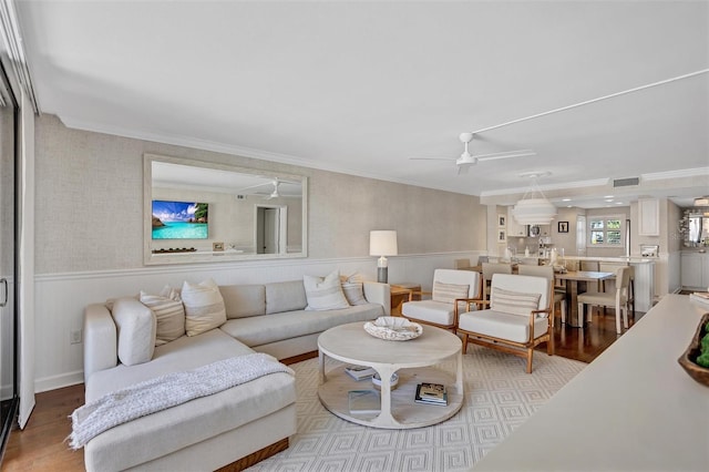 6480 Midnight Pass Rd Unit 211, Sarasota, FL 34242 - living area with wood finished floors, wainscoting, a ceiling fan, and crown molding