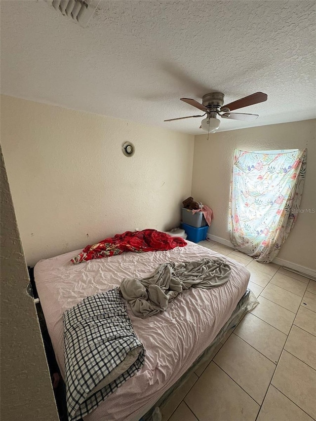 712 W Myrtle St, Lakeland, FL 33815 - tiled bedroom featuring a ceiling fan and a textured ceiling