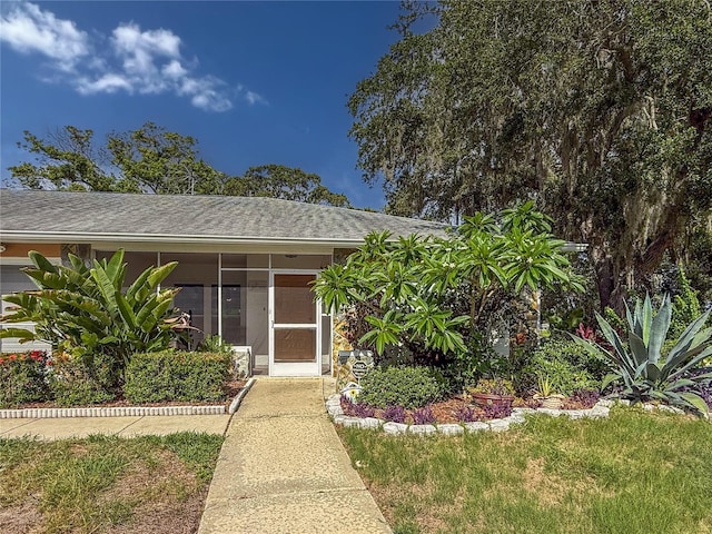 8606 Gold Pine Dr, Port Richey, FL 34668 - view of front of house featuring roof with shingles and a sunroom