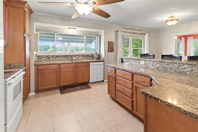8606 Gold Pine Dr, Port Richey, FL 34668 - kitchen featuring white appliances, brown cabinetry, plenty of natural light, stone countertops, and crown molding