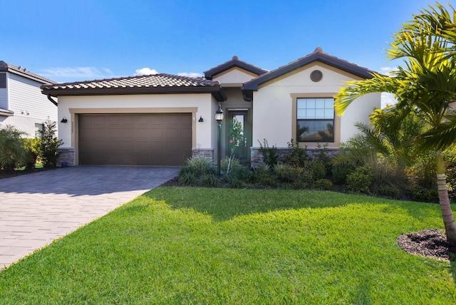 15992 Honey Suckle St, Port Charlotte, FL 33953 - view of front of home featuring a garage, decorative driveway, a front lawn, and stone siding