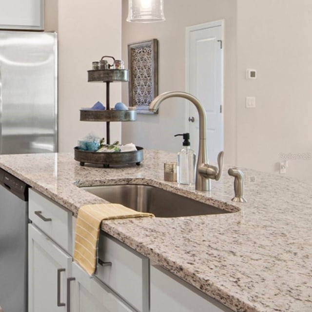 15992 Honey Suckle St, Port Charlotte, FL 33953 - kitchen featuring light stone counters, appliances with stainless steel finishes, and white cabinets