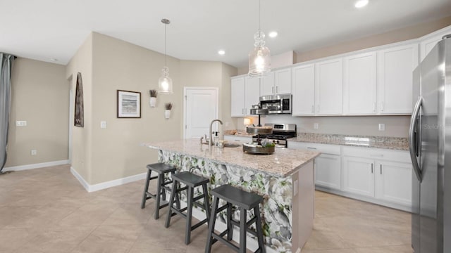 15992 Honey Suckle St, Port Charlotte, FL 33953 - kitchen with appliances with stainless steel finishes, a kitchen island with sink, white cabinetry, recessed lighting, and a kitchen bar