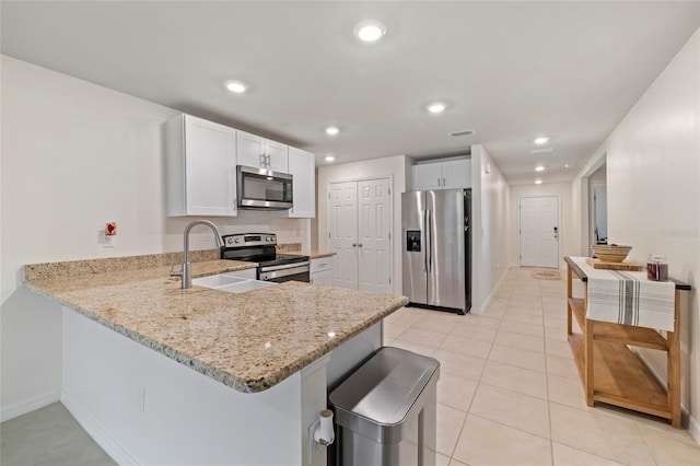 24748 Rio Villa Lakes Cir, Punta Gorda, FL 33950 - kitchen with stainless steel appliances, a peninsula, light stone countertops, recessed lighting, and white cabinets